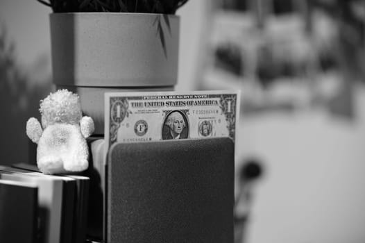 A one dollar bill laying on top of a speaker next to a plush dog