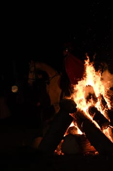 Large blazing bonfire at night with St. Martin on horseback in background in Huenxe, Germany
