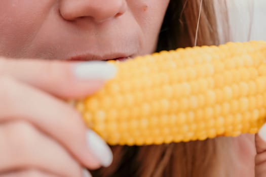 Healthy vegetarian hipster woman in summer outfit eat grilled corn and look to camera. Sexy lady on sea beach sunset or ocean sunrise. Travel, explore, active yoga and meditation lifestyle concept.