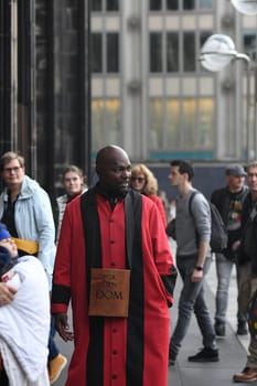 Vertical shot of the Cathedral servant in front of Cologne Cathedral in a red robe, Cologne, Germany