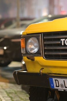 Front view with details of a parked old yellow Toyota Landcruiser in Duesseldorf, Germany