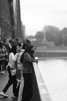 Masked people lean over the railing of the Hohenzollern bridge in Cologne, Germany