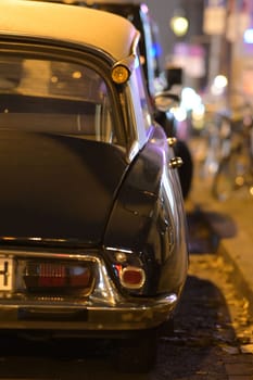 Black french classic car parked in front of other cars at night in Duesseldorf, Germany