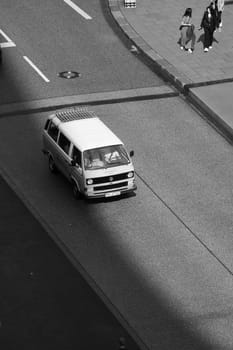 Vertical black and white shot of a Volkswagen Bulli on an empty road