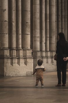 Little boy looks in wonder at the huge stone columns in Cologne Cathedral in Cologne, Germany