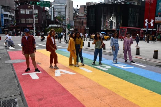 People standing on a rainbow crosswalk in Taipei, Taiwan