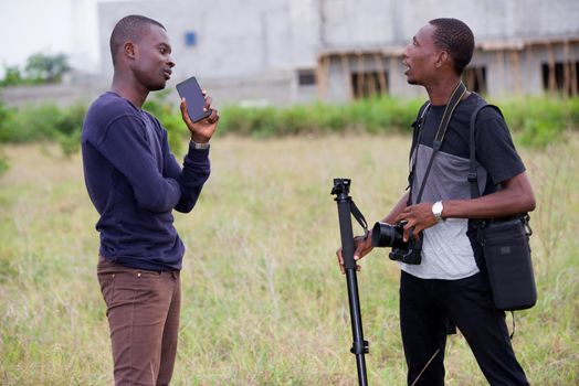 two young men photographers discussing together after a walk and a study session on nature.