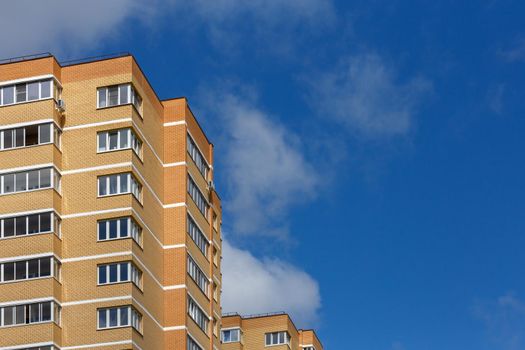 new high rise yellow-orange brick apartment buildings at sunny day light, close-up telephoto view.
