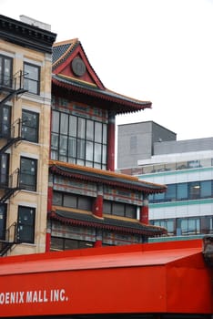 Vertical shot of a Chinese temple next to New York townhouses