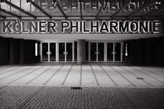 Grayscale shot of the entrance and illuminated sign of the Koelner Philharmonie in Cologne, Germany