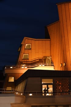 Vertical shot of the golden building of the Berlin Philharmonic Hall at night in Berlin, Germany