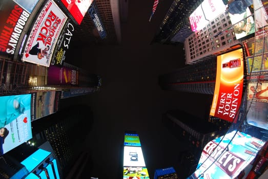 Low angle shot of billboards and neon signs on skyscrapers in the Times Square in New York at night