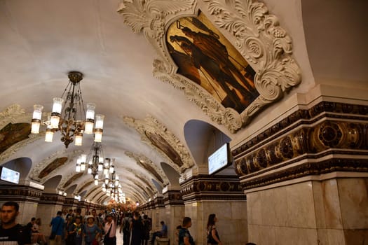 Paintings, stucco, and chandeliers on the ceiling of a subway station in Moscow, Russia