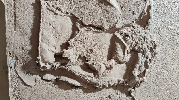 Plastering cement at wall for renovation house. Putty grey brick wall background. Partly plastered new brick wall with wet plaster for abstract background and texture