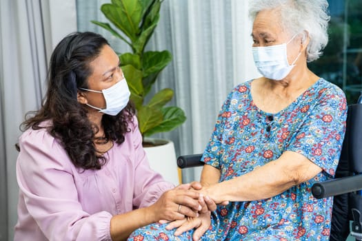 Caregiver help Asian senior woman on wheelchair and wearing a face mask for protect safety infection Covid19 Coronavirus.
