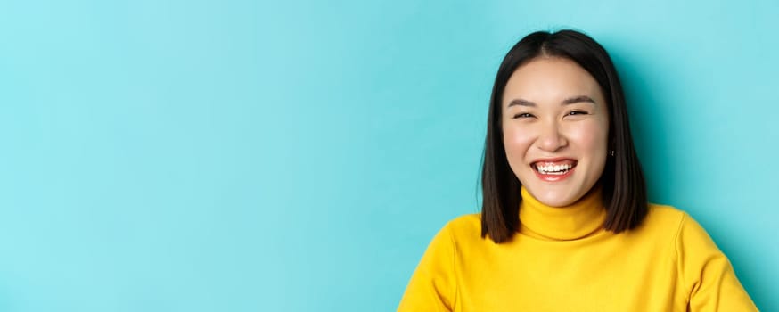 Beauty and makeup concept. Close up of carefree teenage girl smiling and laughing sincere, having fun, standing over blue background.