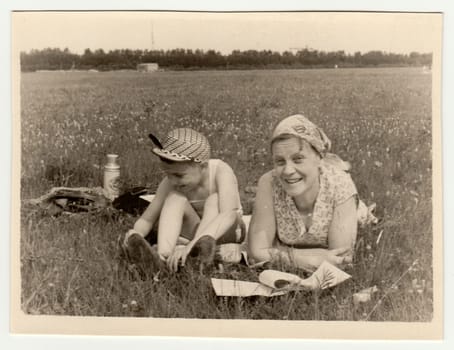 USSR - CIRCA 1970s: Vintage photo shows a mother with son have a rest on meadow