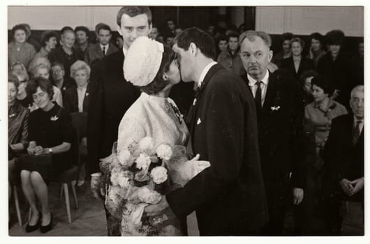 TEPLICE, THE CZECHOSLOVAK SOCIALIST REPUBLIC - OCTOBER 15, 1966: Vintage photo of wedding ceremony - bridal kiss