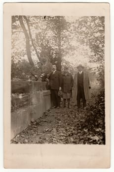 THE CZECHOSLOVAK REPUBLIC - CIRCA 1940s: Vintage photo shows people in the city park. People stay at the stone sculpture.