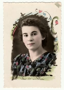 USSR - CIRCA 1960s: Vintage portrait shows a young woman. Antique photo with delicate floral background (Russian tradition to decorate photos).