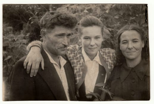 USSR - 1950: Vintage photo shows daughter with parents outdoors.