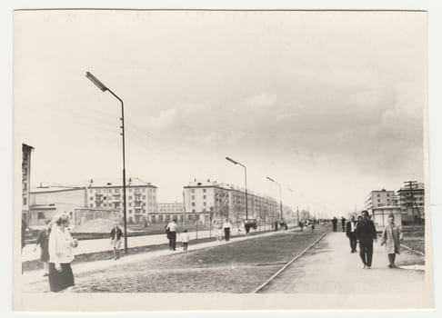 USSR - CIRCA 1980s: Vintage photo shows people walk along the boulevard. Blocks of flats on background.