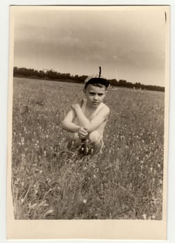 USSR - CIRCA 1980s: Vintage photo shows boy sits on meadow.