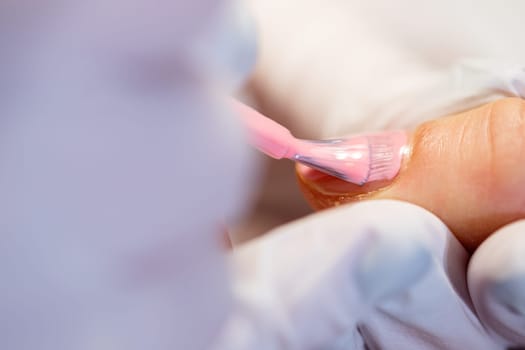 Preparation of the nail plate for further cosmetic procedures. Maintaining the principles of hygiene in the beauty salon. Working as a beautician and manicurist. Close-up on the hands of a beauty salon client.