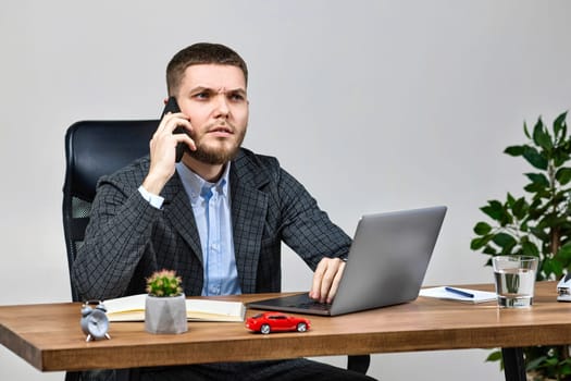 businessman working with laptop and talking on the phone