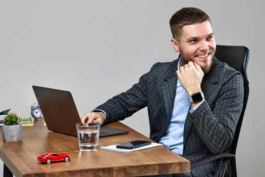 young happy bearded man sitting at desk work on laptop pc computer