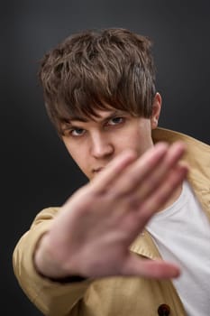 man doing stop sing with palm of the hand on black background.