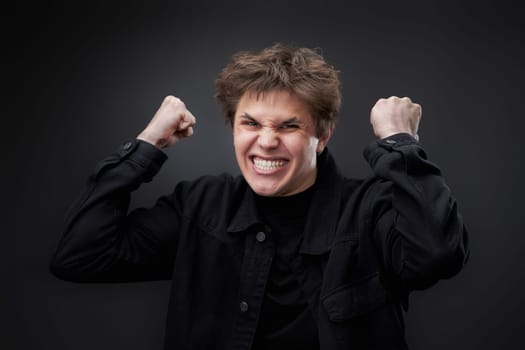 annoyed angry man in furious gesture on black studio background