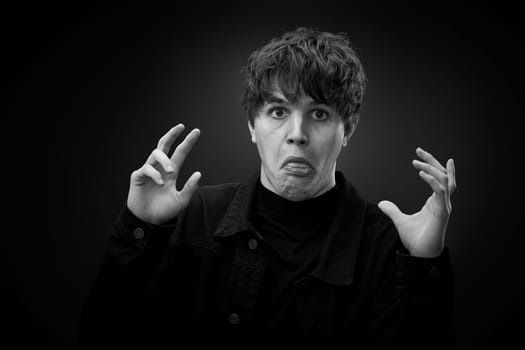 portrait of crazy young man showing the tongue and grimacing . black and white