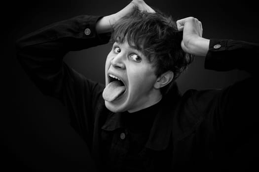 portrait of crazy young man showing the tongue and grimacing . black and white