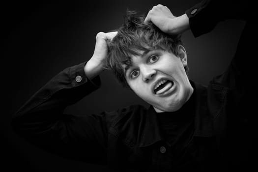 portrait of crazy young man showing the tongue and grimacing . black and white