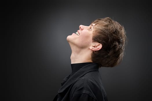 side view of positive handsome man with hairdo on black background. copy space