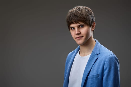 handsome caucasian man looking at the camera on gray studio background. copy space