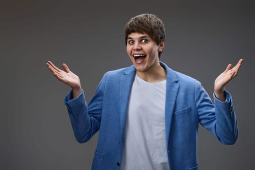 happy surprised man with excited face on gray studio background