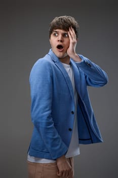 shocked man with surprise expression, fear and excited face on gray studio background