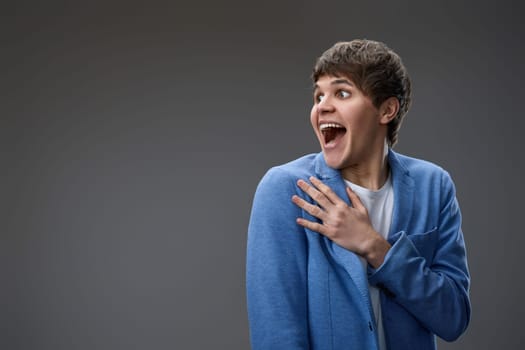 happy shocked man with surprise expression and excited face on gray studio background