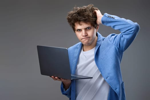 Funny and crazy caucasian man with laptop on gray background