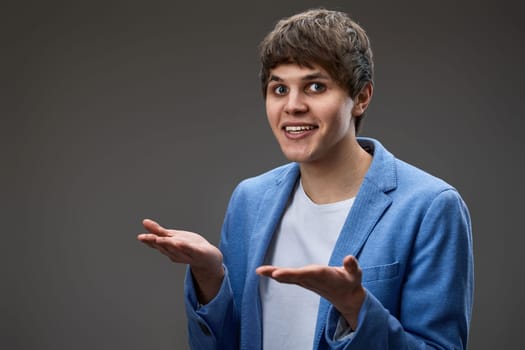 happy surprised man with excited face on gray studio background. copy space