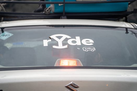 Chandigarh, India - circa 2023: Sedan car with sticker for Ryde by Redbus a taxi cab hailing startup for travelling intercity for business, vacation or fun