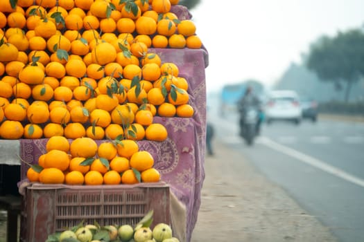 oranges kinnu citrus fruit piled up at a roadside stall showing how farmers traditionally sell this local fruit in India for eating and juice as a healthy item in summer months