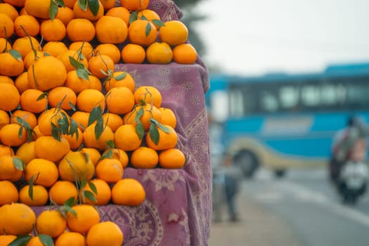 oranges kinnu citrus fruit piled up at a roadside stall showing how farmers traditionally sell this local fruit in India for eating and juice as a healthy item in summer months