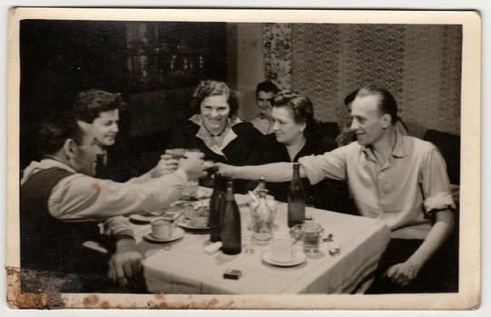 THE CZECHOSLOVAK SOCIALIST REPUBLIC - CIRCA 1960s: Vintage photo shows women and men propose a toast. Photo has dirt as it has been found in loft.