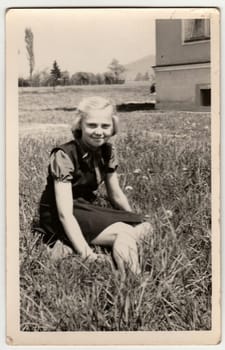 THE CZECHOSLOVAK SOCIALIST REPUBLIC - CIRCA 1960s: Vintage photo shows girl sits on grass.