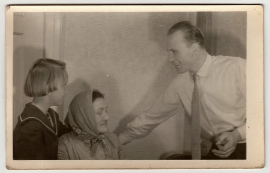 THE CZECHOSLOVAK SOCIALIST REPUBLIC - CIRCA 1950s: Vintage photo shows father, daughter and grandmother at home.