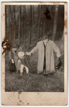 THE CZECHOSLOVAK SOCIALIST REPUBLIC - CIRCA 1960s: Vintage photo shows women and girl go for a walk in forest. Photo has dirt as it has been found in loft.