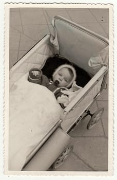 HODONIN, THE CZECHOSLOVAK REPUBLIC - CIRCA 1940: A vintage photo shows a small baby girl in a pram (baby carriage).
